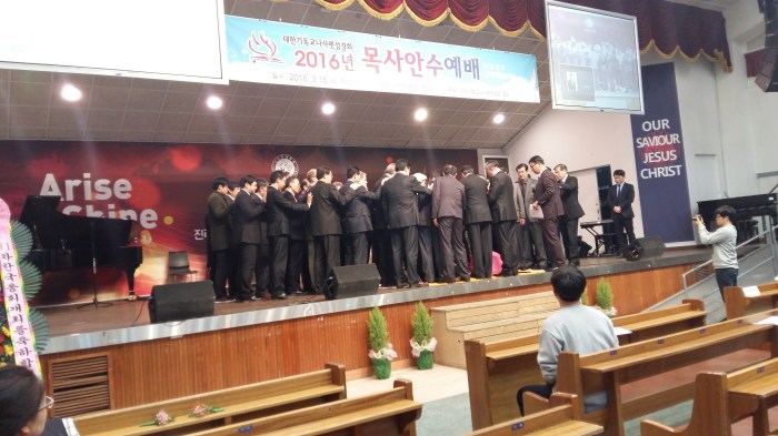 One by one, the ordiands and their spouses knelt on the platform, were prayed for, and ordained by Dr. Graves as the elders of the district laid hands on them. This is one of the most moving parts of the service and most of the ordinands and their spouses were noticeably moved.